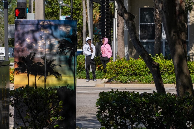 Some people are crossing a sidewalk in Blanche Ely, Pompano Beach.