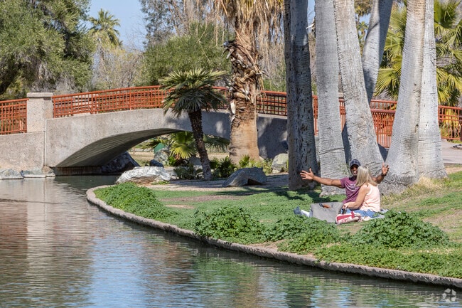 A couple enjoys a picnic alongside the water at Phoenix’s Encanto Park.