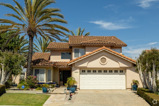 This Mediterranean stlye home in Shadowridge has a large king palm tree in the front.