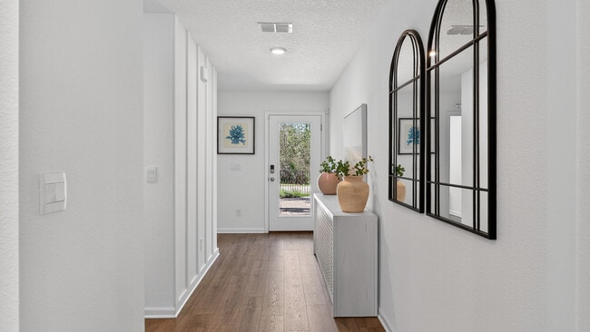 Hallway with hardwood flooring, recessed lighting, and arched mirror. - 836 Grand Reserve Dr, Bunnell, FL 32110