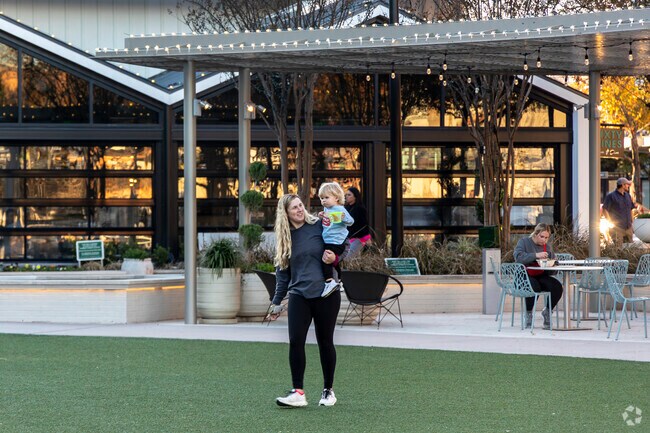 Visitors play in the common area at the center of Market Street near Research Forest.
