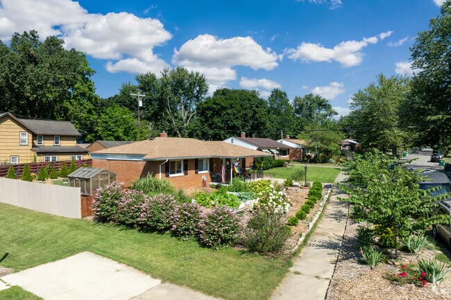 A charming ranch house features a well-maintained lawn, accented with wildflowers.
