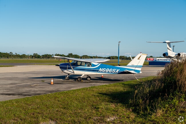 At the local airfield, small aircraft rest peacefully.