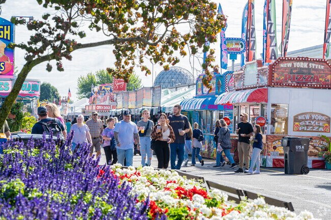 People stroll along a thoroughfare with beverages in hand at the Big E in West Springfield.