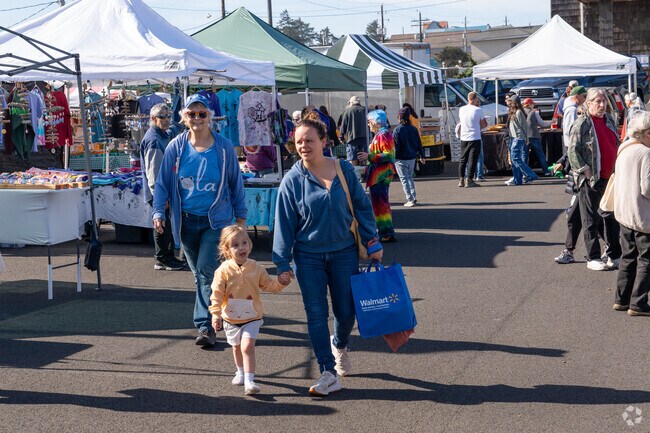 Families enjoy the many booths at the local Farmer's Market.