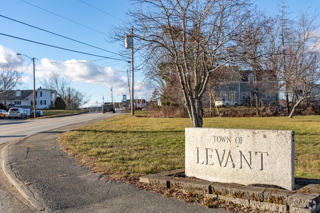 Levant's granite signage marks the entrance to the town along a quiet roadside.