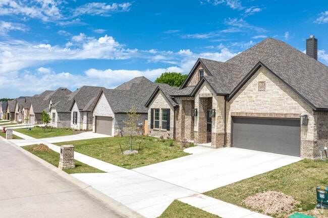 Row of homes include traditional brick houses with built-in garages in Decatur, TX.