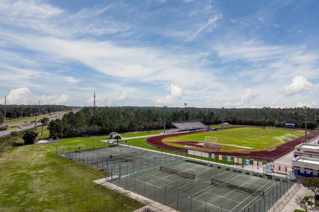 Harmony High School's sports field features tennis, basketball, and football.