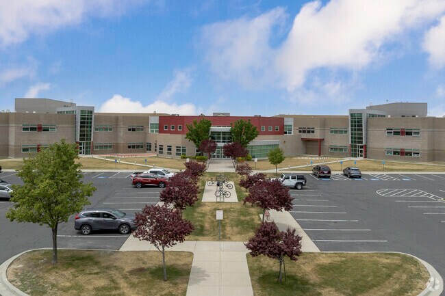 A tree lined sidewalk leads to the entrance at Northwest Middle School in Rose Park.