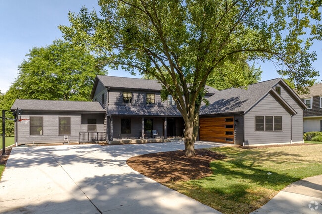 A modern custom-build home with dark siding and front porch located in Southeast Wheaton.