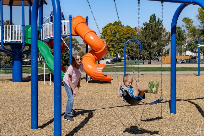 A child enjoys the swings at River Run Park with his grandma in River Run.