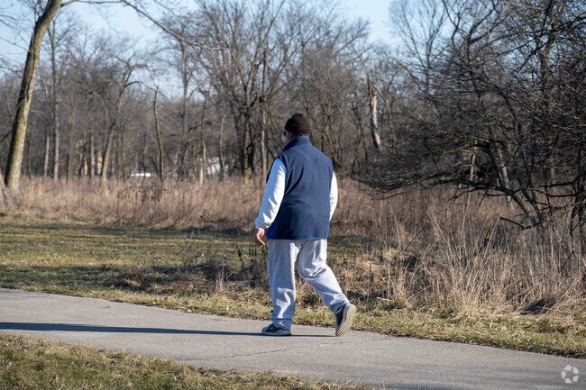 A man enjoys a leisurely walk on trails in Kickapoo Meadows Park near the Phoenix, IL area.