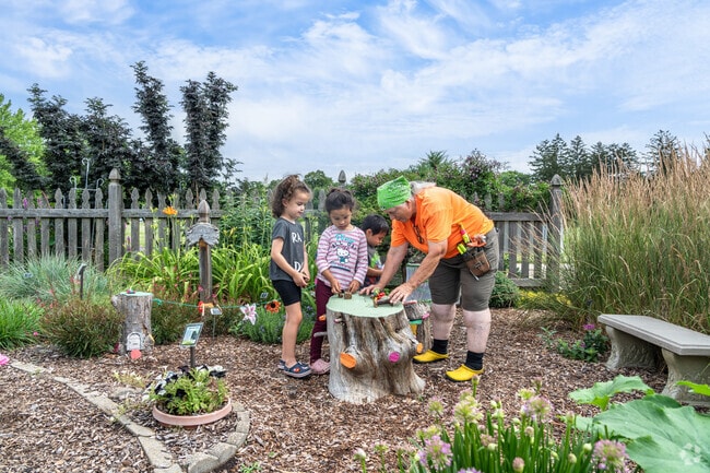 A volunteer gardener talks with kids at the University Of Illinois Arboretum near West Urbana.
