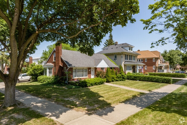 A brick cottage sits beside an American Foursquare home in Aviation.