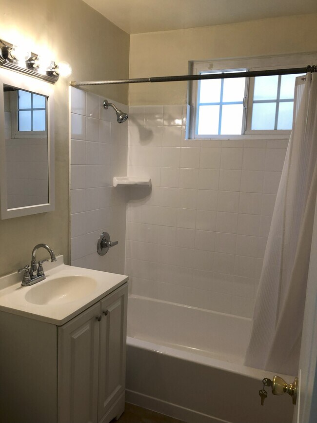 Newly glazed tub and tile shower with new mirror and medicine cabinet.