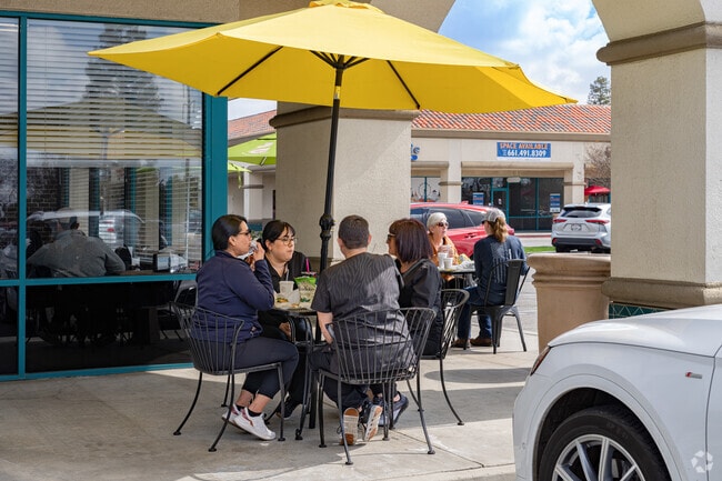 A group of Fruitvale friends enjoys lunch outdoors on a warm summer day.