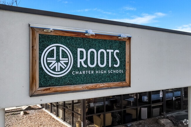 Roots Charter High School has a black and natural wood sign.