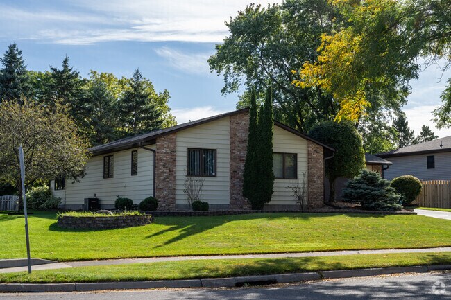 Well-maintained single-story home in Maplewood Heights, featuring classic brick accents and mature landscaping on a quiet tree-lined street.