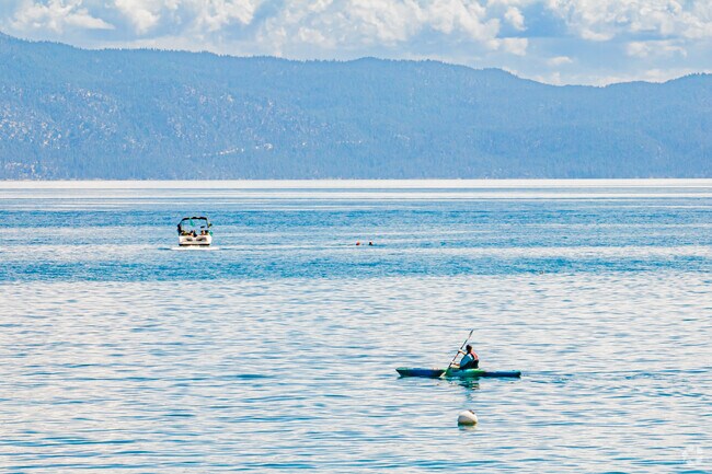 A kayaker watches a wakeboarder get ready on Lake Tahoes calm waters in Carnelian Bay..