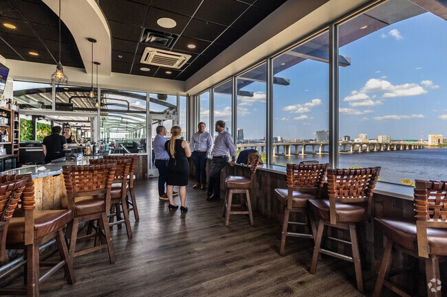People gather to socialize and enjoy the view at River & Post Rooftop Bar.