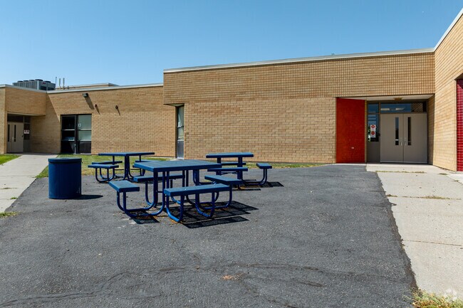 Blue picnic tables are located behind Hunter Elementary School.
