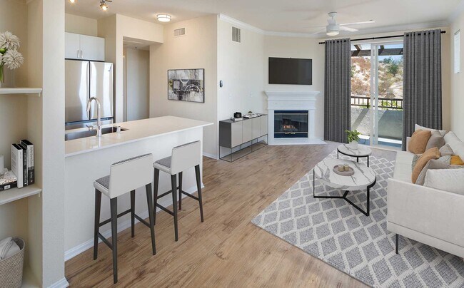 Renovated Package I kitchen and living room area with open concept floor plan, fireplace, and hard surface flooring