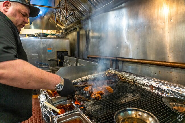 A chef at Firefly's BBQ in Marlborough flips wings on the grill.