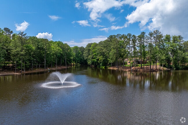 A peaceful lake with a fountain adds to the natural charm surrounding Seven Oaks, offering scenic spots to relax or take a quiet walk.