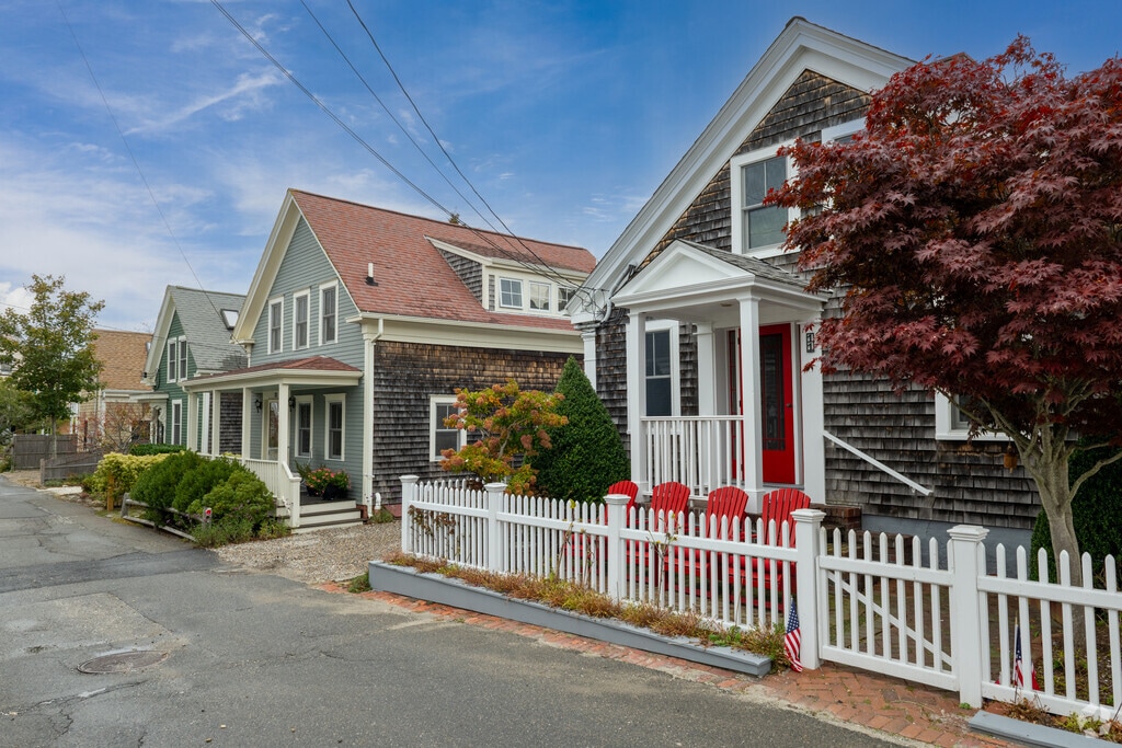 Picket fences line Cape Cod-style homes along a quiet Provincetown street.