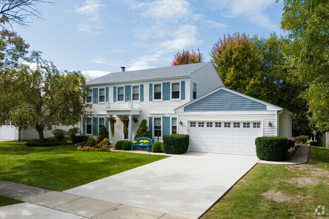 A colonial-inspired home in Greentree sits on a lot surrounded by trees.