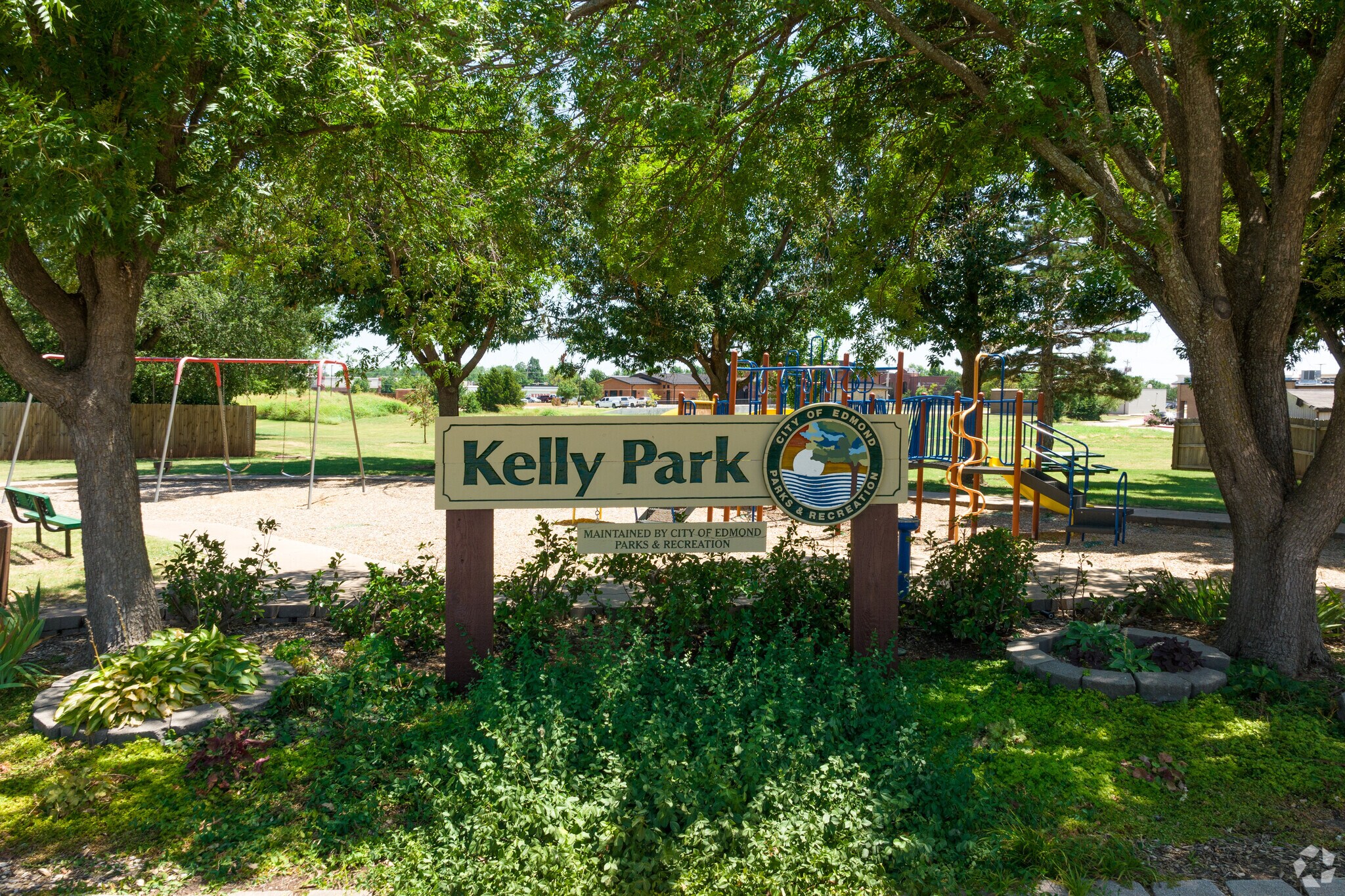 Kelly Park is located along a neighborhood street with many trees and houses.