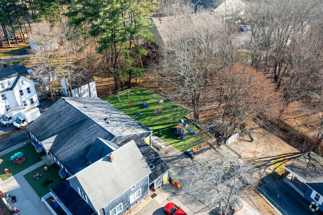 First Steps Children's Center in Hudson has a backyard with a green turf and play sets.