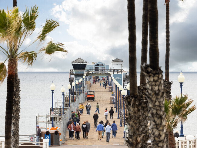 Looking down oceanside pier lots of people walk to get a better view of the ocean in California.