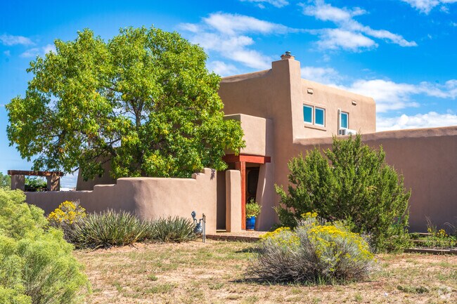 Yucca cacti and a juniper tree adorn the outside of this Santa Fe style home.