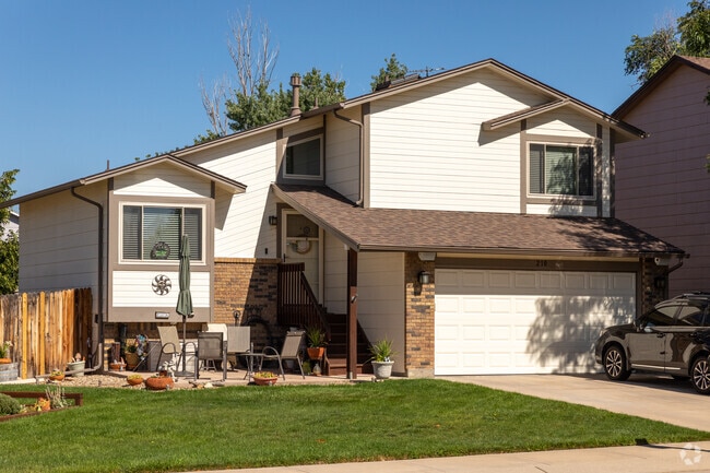 A split level home in Fountain Valley Ranch featuring a large front yard and a two car garage.