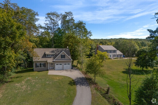 Two Colonial-style homes sit side by side in a more rural area of Colchester.
