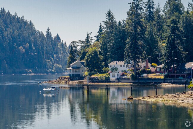 A moored boat just off the coast of Rocky point surrounded by stunning homes.