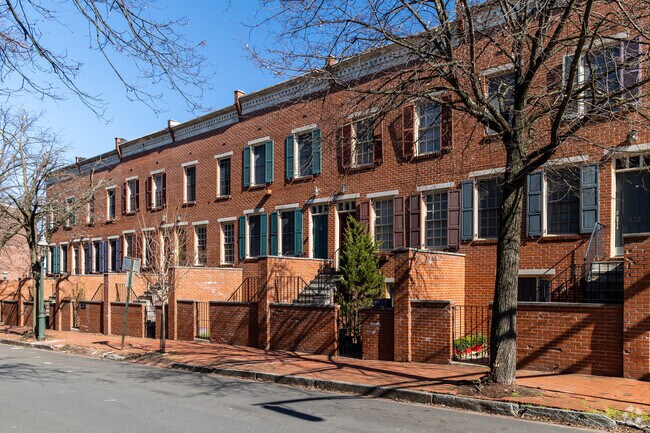 Three-story brick homes have small, enclosed front yards.