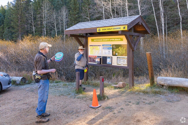 A couple of Deer Creek friends look over the disc golf course before teeing off.