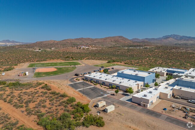 The grounds of High Desert Middle School include a dedicated ball field and athletic areas, all framed by desert ridges and blue skies.
