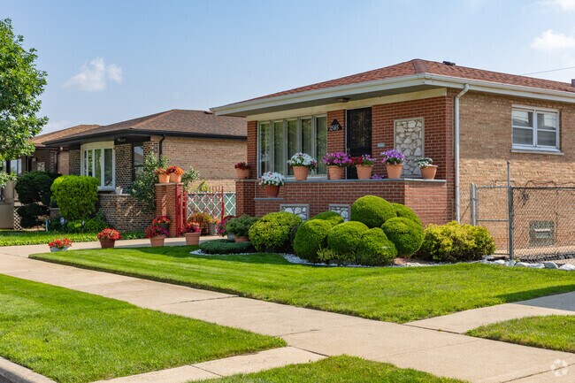 Classic bungalow style homes, green grass with landscaping, East Side, Chicago, IL.