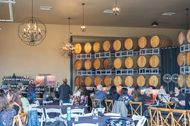 A paint and wine tasting class takes place at McGrail Winery in their large barrel room venue.
