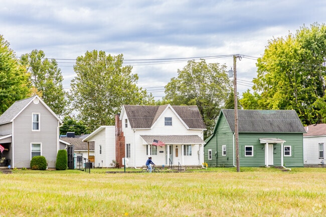 A cyclist rides past a row of traditional single family homes in Thomas Park - Avondale.