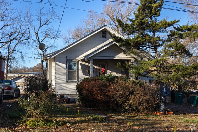 Peeking from behind the landscaping is a 1920's bungalow in Charlack.