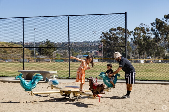 A family gathers to play at Sabre Springs Park.
