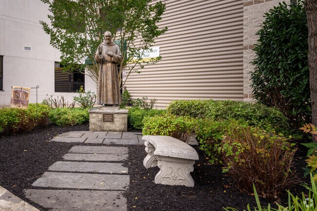 Padre Pio stands vigil over the garden at St. Thomas Apostle School.
