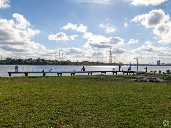 At the end of the pier, fishing poles stand tall, their lines dancing playfully in the water.