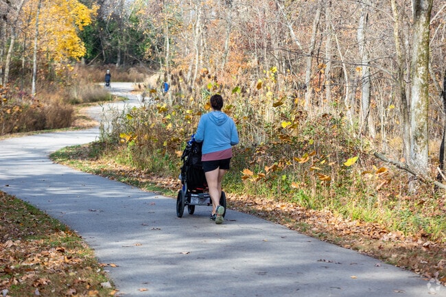 Residents in Oakville enjoy sunny walks on paved trails at Cliff Cave Park.