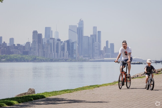 A father and son bike along the Hudson River Waterfront Walkway in Edgewater, NJ.