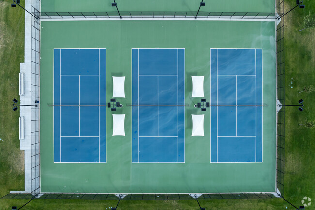 Blue and green tennis courts sit in symmetry at Kearns High School.